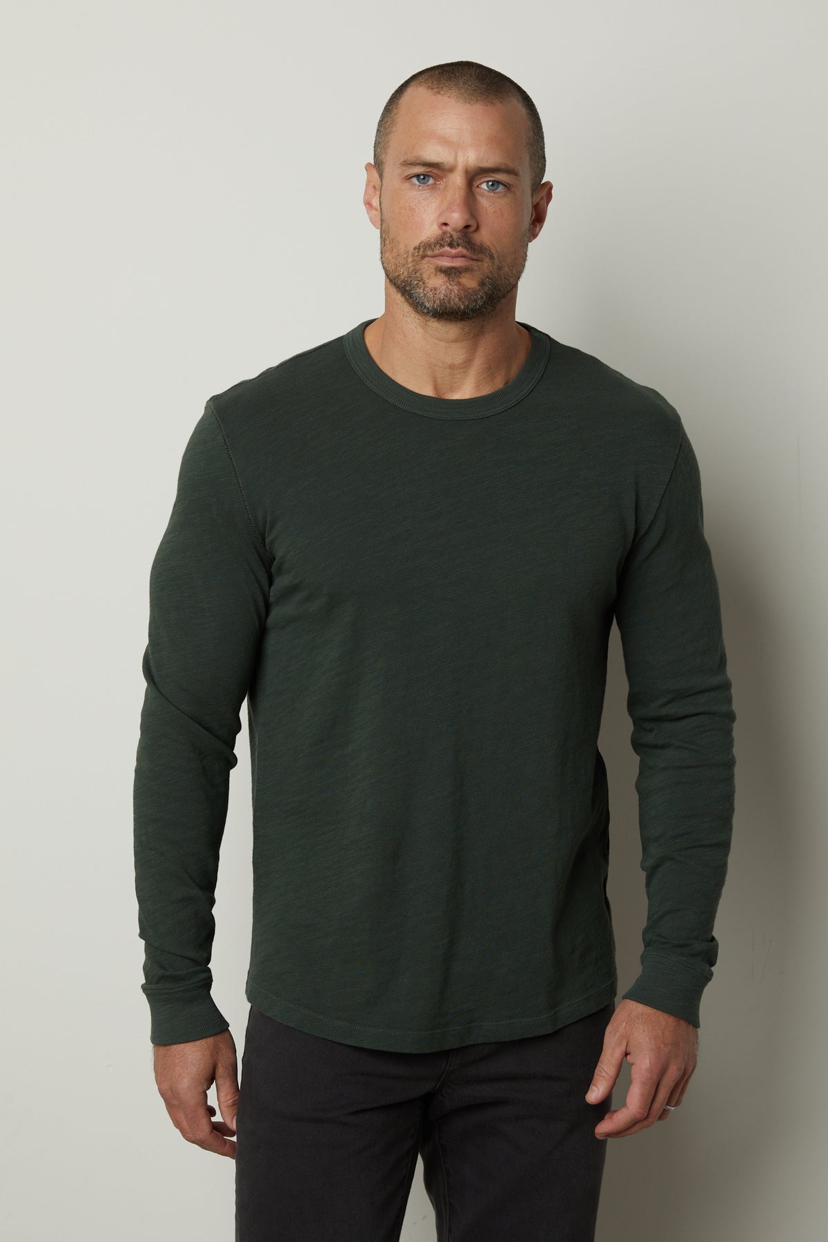   A man wearing a Velvet by Graham & Spencer PALMER CREW NECK TEE with ribbed cuffs. 