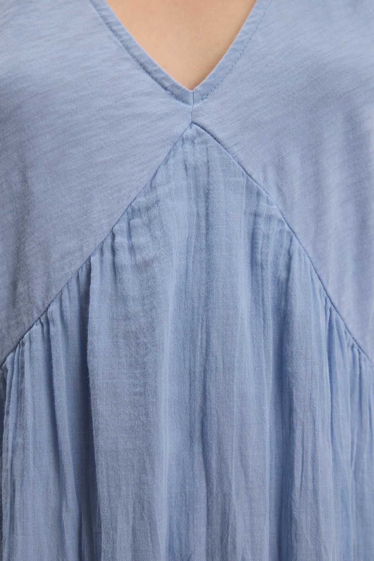 Close-up of the LILY DRESS by Velvet by Graham & Spencer, a light blue mini dress featuring a V-neck, relaxed fit, and gathered fabric detail below the neckline.-39111854489793