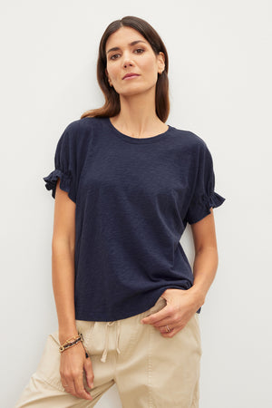 The model is wearing a Velvet by Graham & Spencer MIMI CREW NECK TEE, a wardrobe essential made of cotton slub fabric.