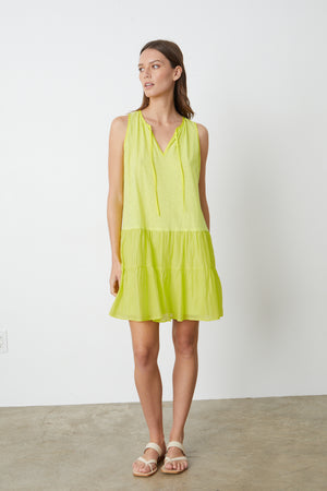 A woman wearing a Velvet by Graham & Spencer PAIGE TIERED DRESS and sandals.