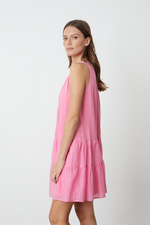 The model is wearing a Velvet by Graham & Spencer PAIGE TIERED DRESS with ruffles.