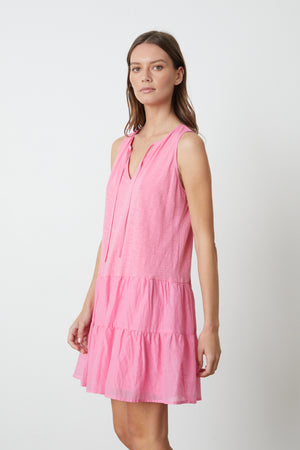 A model wearing a Velvet by Graham & Spencer Paige Tiered Dress with ruffles.