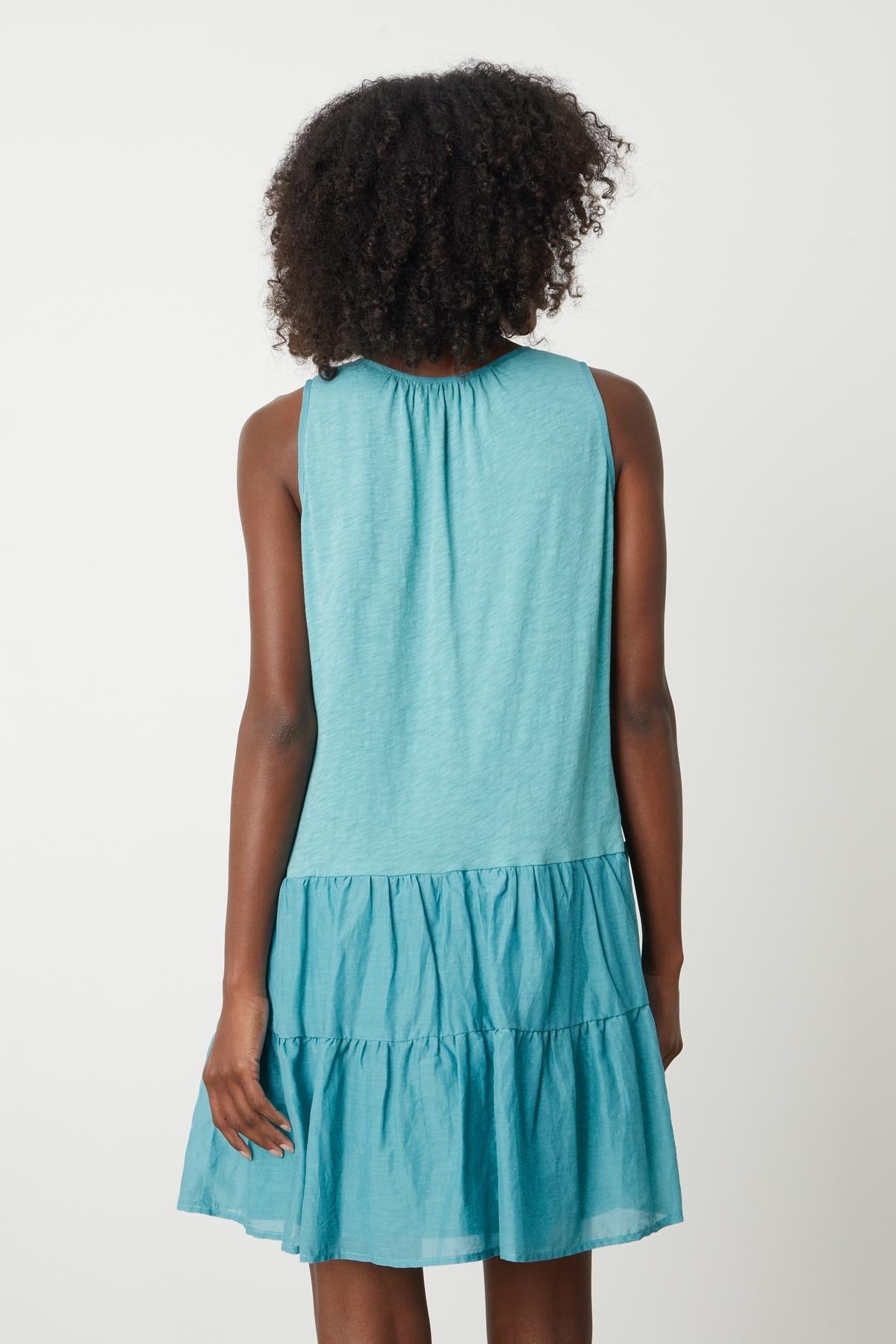 The back view of a woman wearing a Velvet by Graham & Spencer PAIGE TIERED DRESS.