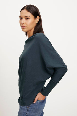 The model is wearing a NOVALEE DOLMAN TEE and jeans by Velvet by Graham & Spencer.