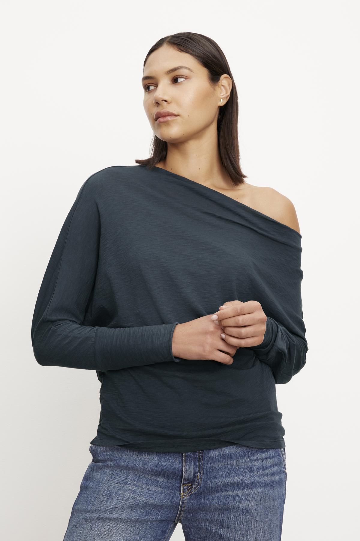 A woman wearing jeans and a Velvet by Graham & Spencer NOVALEE DOLMAN TEE.