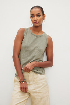 A woman wearing a Velvet by Graham & Spencer TAURUS COTTON SLUB TANK and beige wide leg pants.