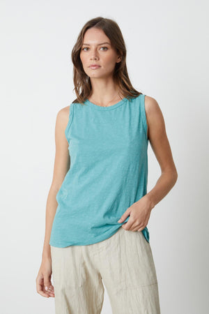 A woman wearing a Velvet by Graham & Spencer TAURUS COTTON SLUB TANK in turquoise with Dru pant front