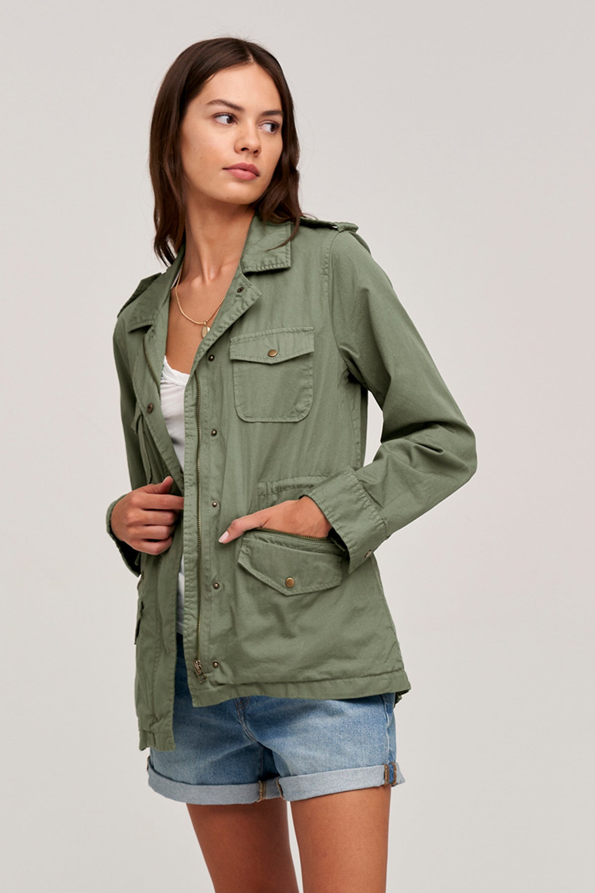 A woman wearing a Velvet by Graham & Spencer RUBY LIGHT-WEIGHT ARMY JACKET and shorts.-35207196278977