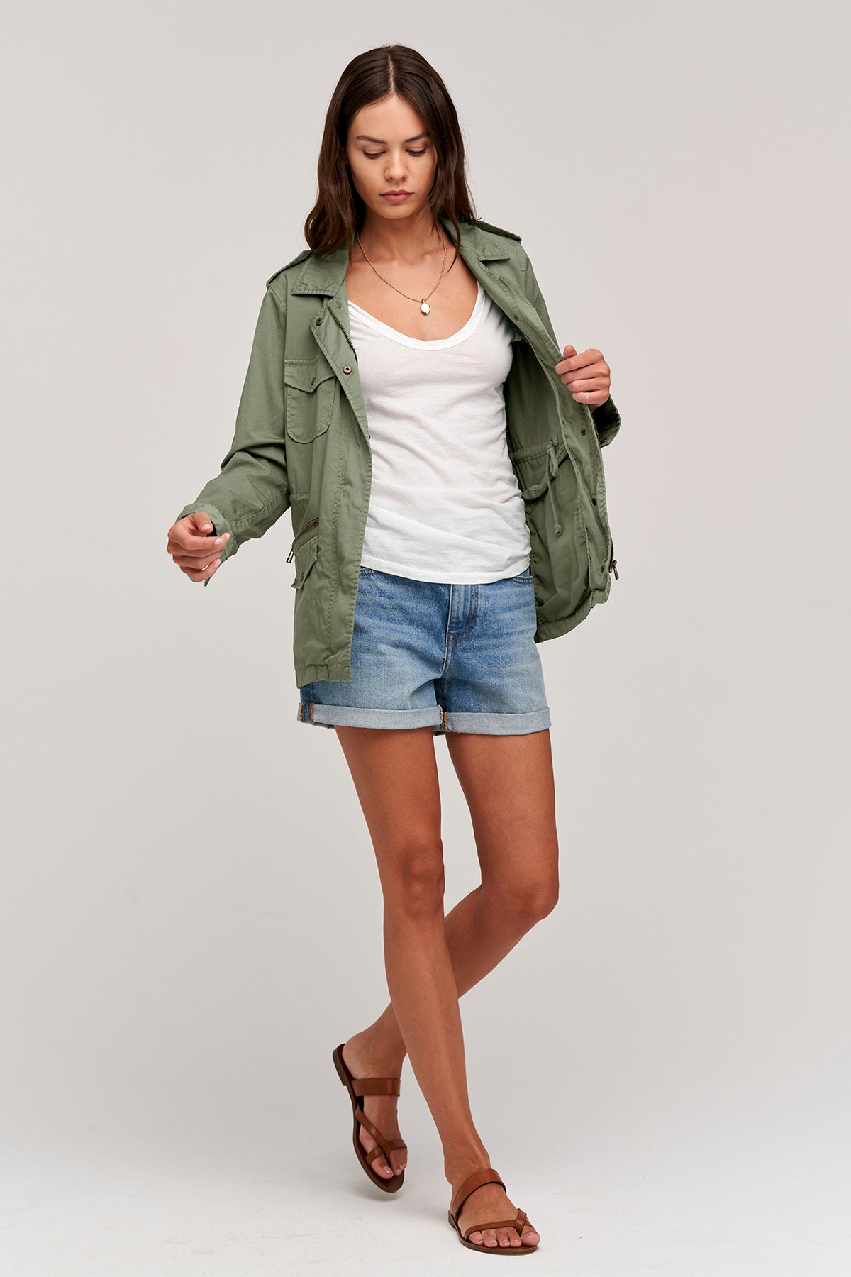 A woman wearing a RUBY LIGHT-WEIGHT ARMY JACKET by Velvet by Graham & Spencer and shorts.