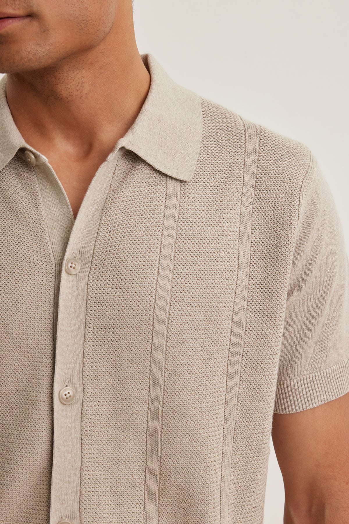 A person wears the LORENZO COTTON LINEN SWEATER POLO by Velvet by Graham & Spencer, featuring a beige textured pattern, button front, and shown from shoulders to mid-torso.-39152720019649