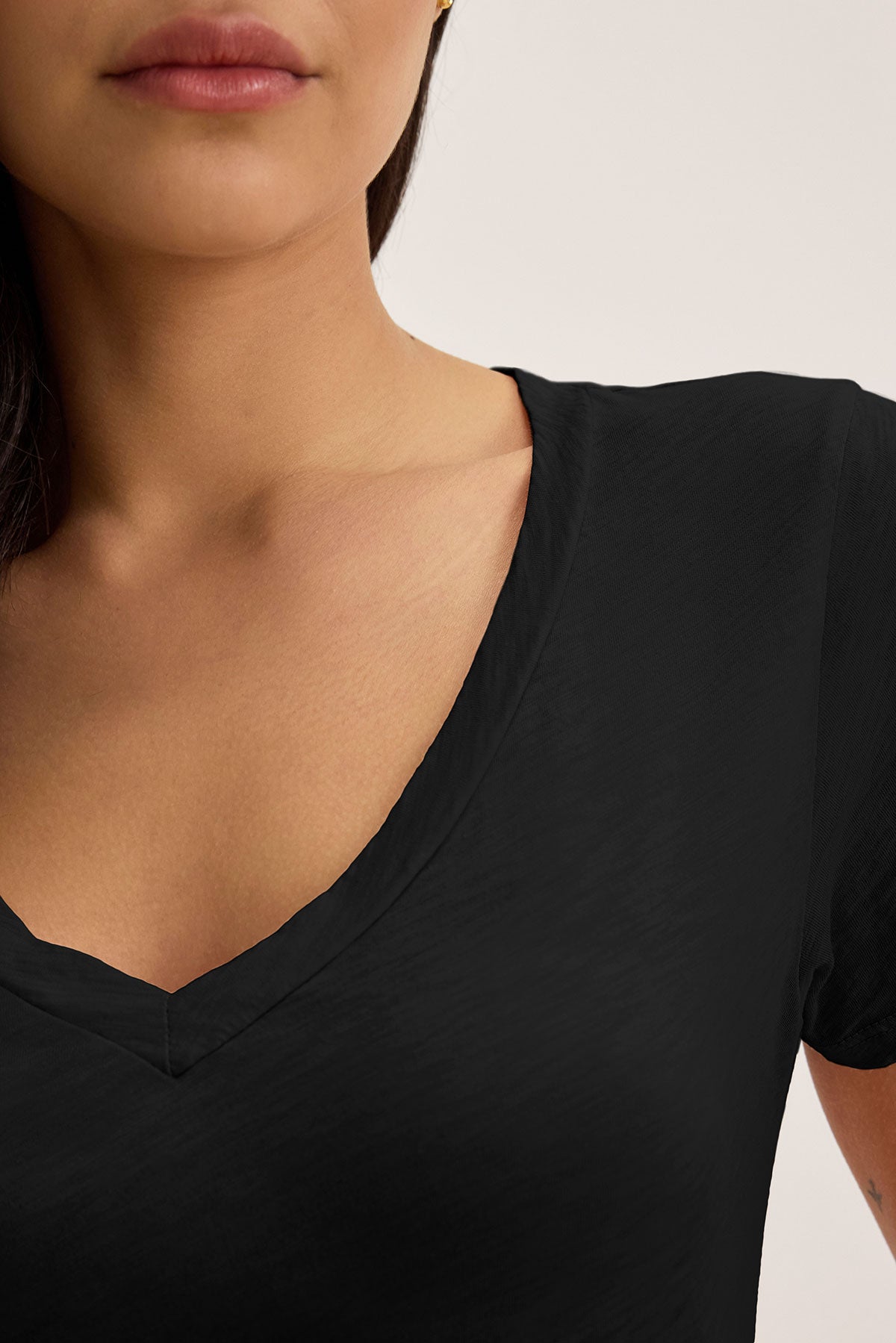 Someone wearing the luxurious LILITH TEE by Velvet by Graham & Spencer, a cotton slub V-neck visible from chest to chin, against a neutral background.