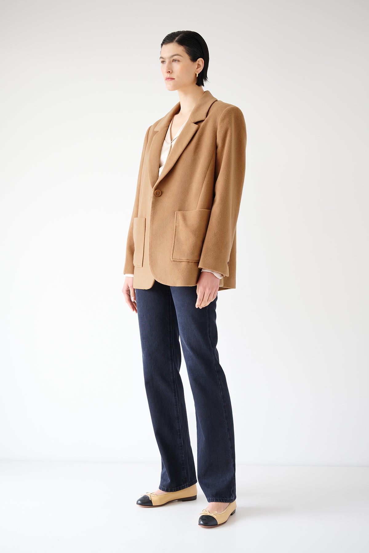 An oversized woman wearing a Velvet by Jenny Graham ALAMOS BLAZER in camel wool blend and blue jeans.-35547423703233