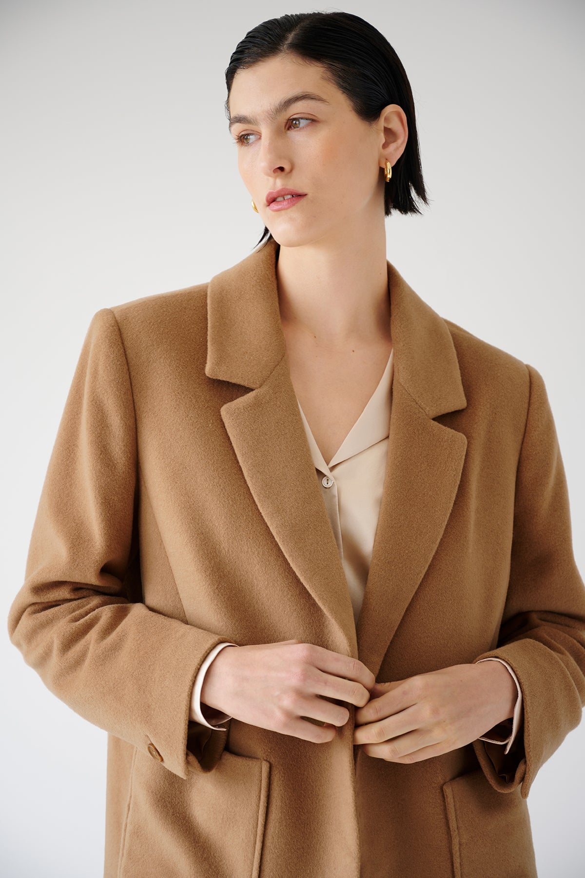   The model is wearing an oversized Velvet by Jenny Graham camel coat. 