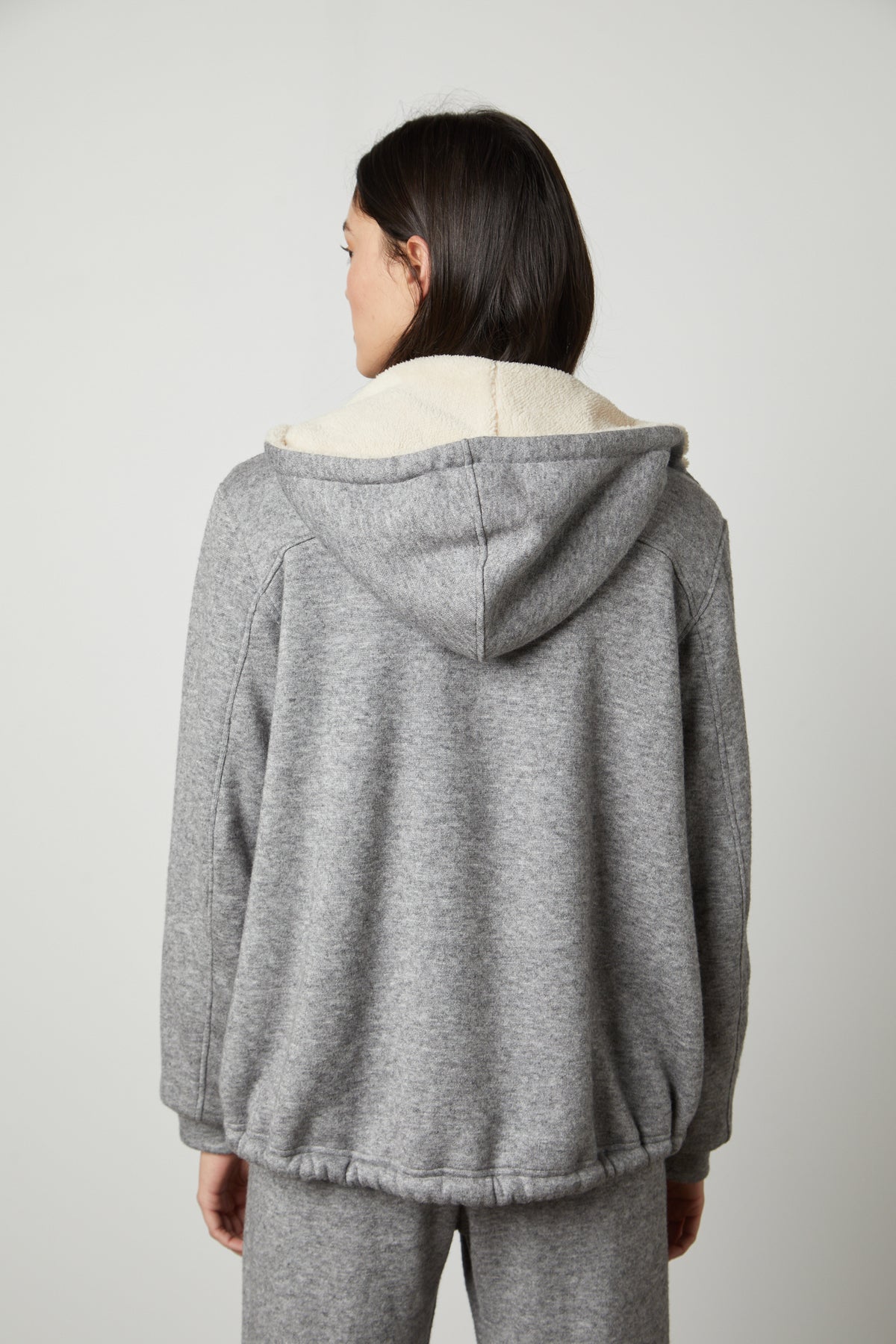 The back view of a woman wearing a Velvet by Graham & Spencer OCTAVIA DOUBLE KNIT ZIP UP HOODIE and sweatpants.-26897841094849