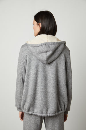 The back view of a woman wearing a Velvet by Graham & Spencer OCTAVIA DOUBLE KNIT ZIP UP HOODIE and sweatpants.
