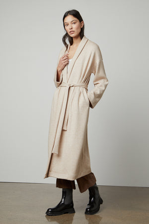 The model is wearing a cozy fabric beige Patricia Double Knit Duster Cardigan with a belt by Velvet by Graham & Spencer.
