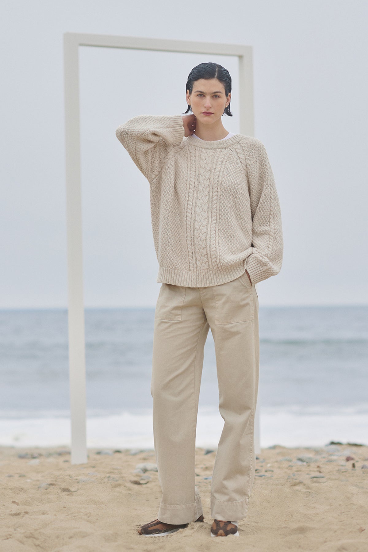 A woman is standing on the beach wearing Velvet by Jenny Graham VENTURA PANT sweater and trousers.-35547785691329