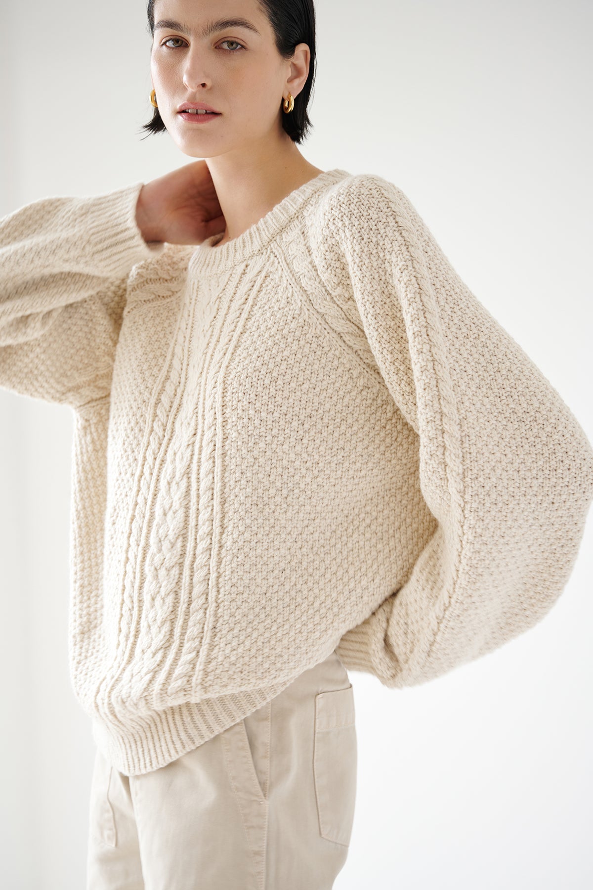 A model showcasing a warm HERMOSA SWEATER by Velvet by Jenny Graham with tan pants, perfect for a cold-weather wardrobe.-35547403223233