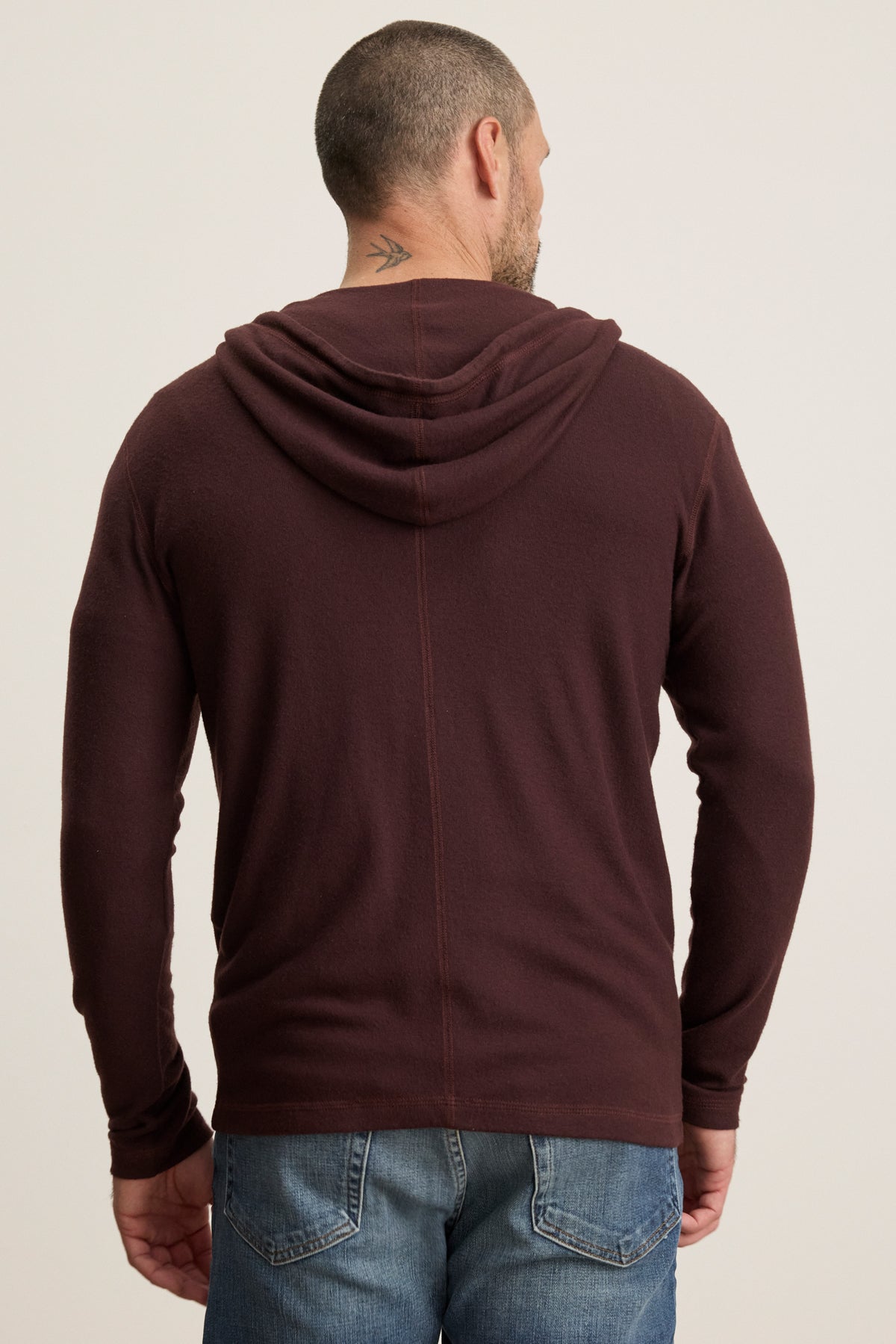 A man is shown from the back wearing the LOUDON HOODIE by Velvet by Graham & Spencer in maroon triblend jersey with blue jeans; a small tattoo is visible on his neck.