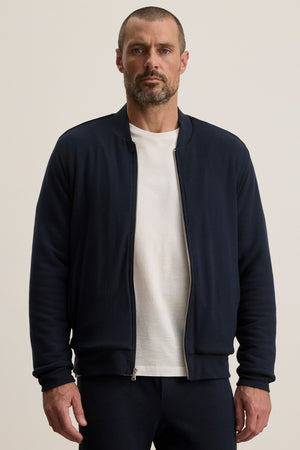 A man wearing the MILES JACKET by Velvet by Graham & Spencer, featuring a soft knit shell and cozy sherpa lining.