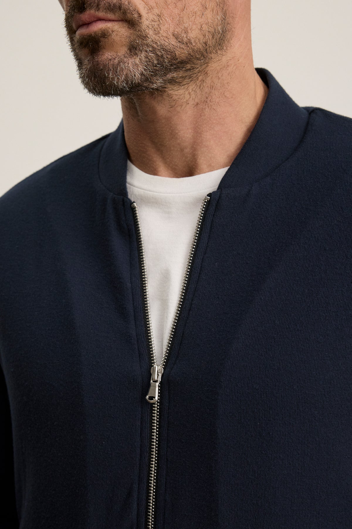 A man wearing the Velvet by Graham & Spencer MILES JACKET in navy blue over a white t-shirt, shown from shoulders to mid-chest.