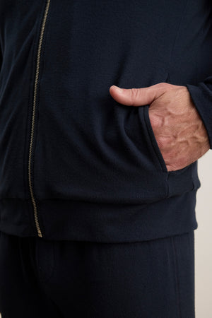 Someone wearing the MILES JACKET by Velvet by Graham & Spencer with their right hand in the jacket pocket, paired with dark casual pants.