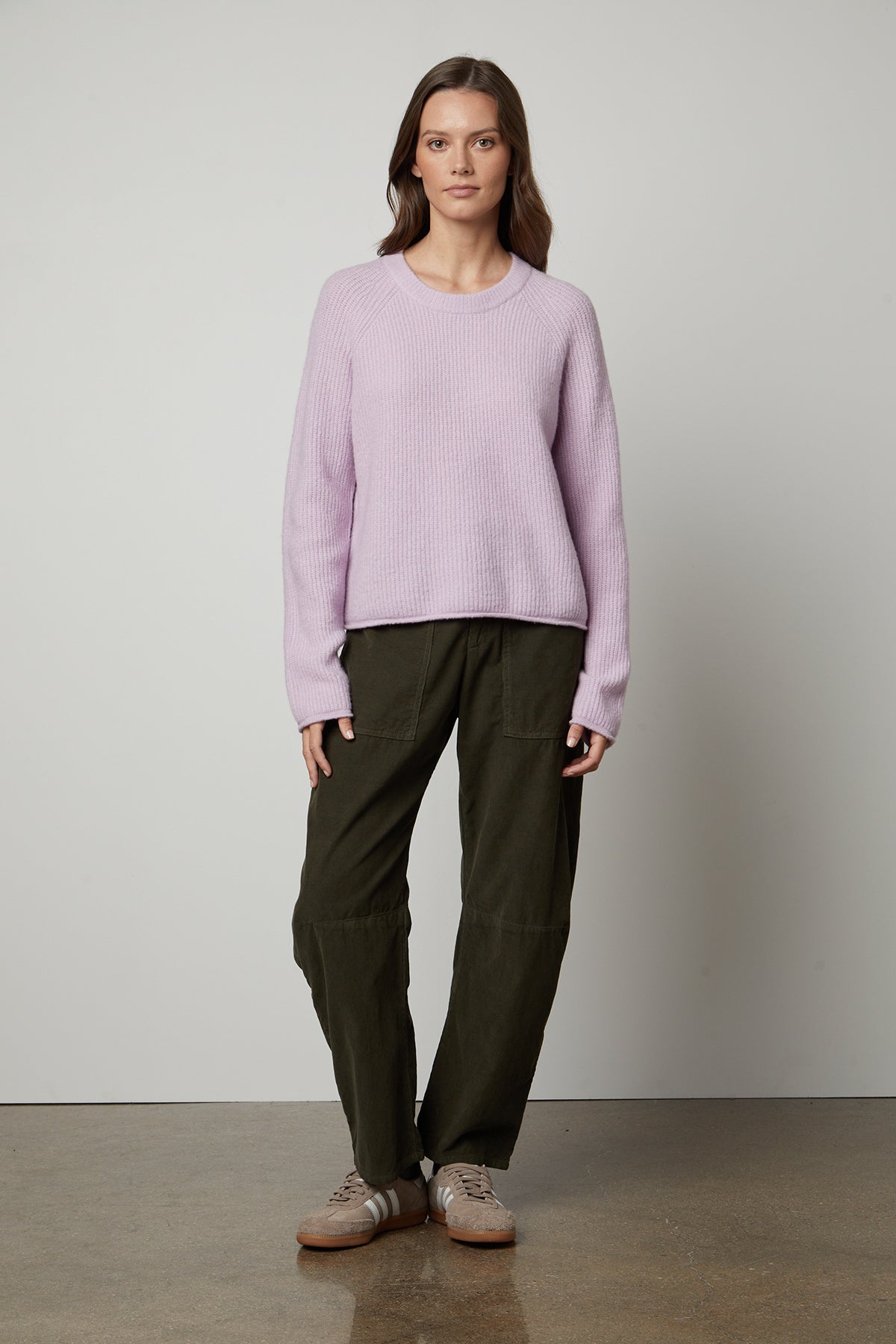 A woman wearing a cozy GIGI CREW NECK SWEATER by Velvet by Graham & Spencer.-35626107797697