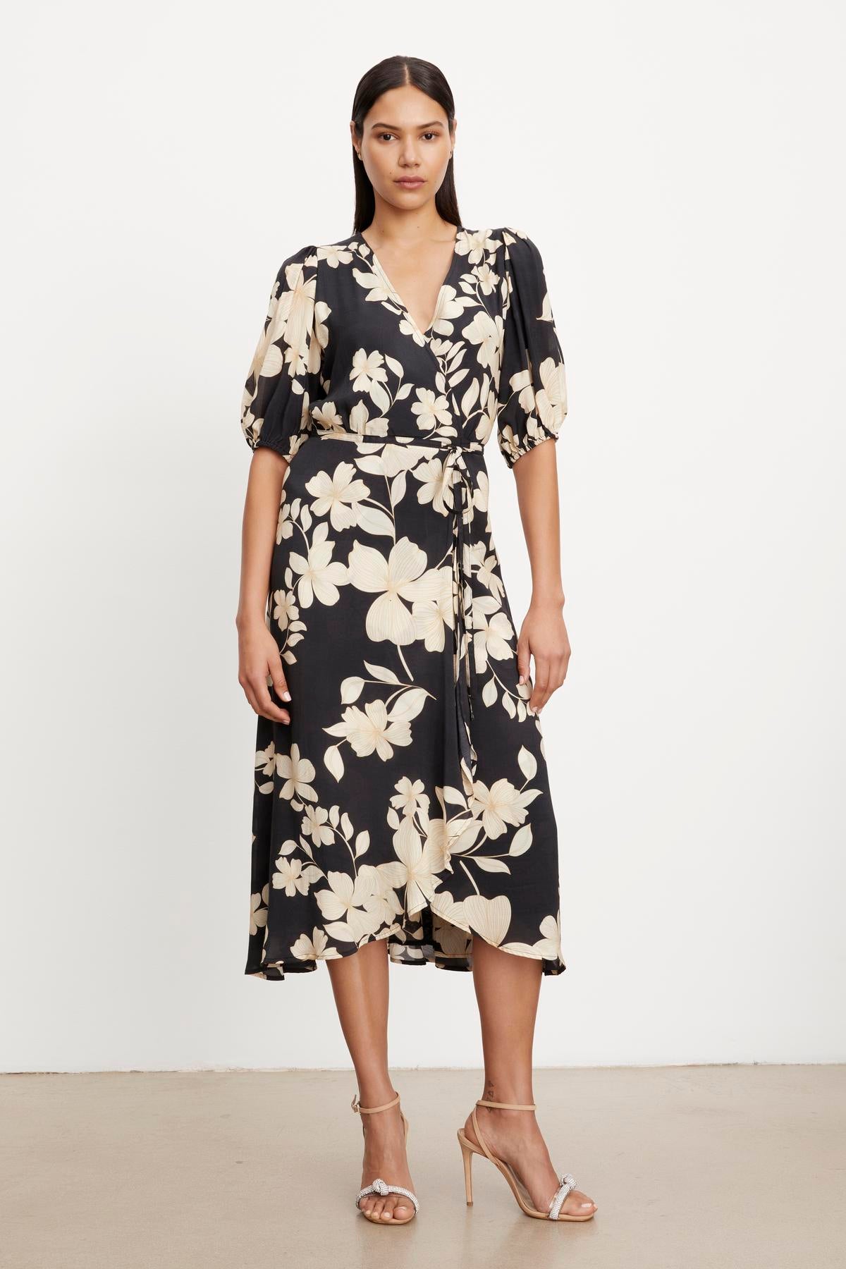 The model is wearing a Velvet by Graham & Spencer KAI PRINTED WRAP DRESS.