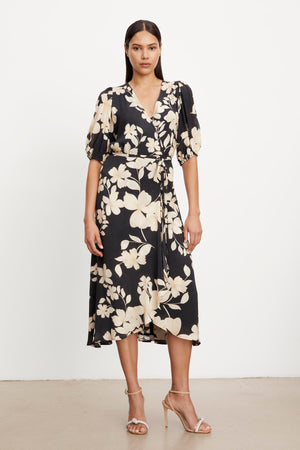 The model is wearing a Velvet by Graham & Spencer KAI PRINTED WRAP DRESS.