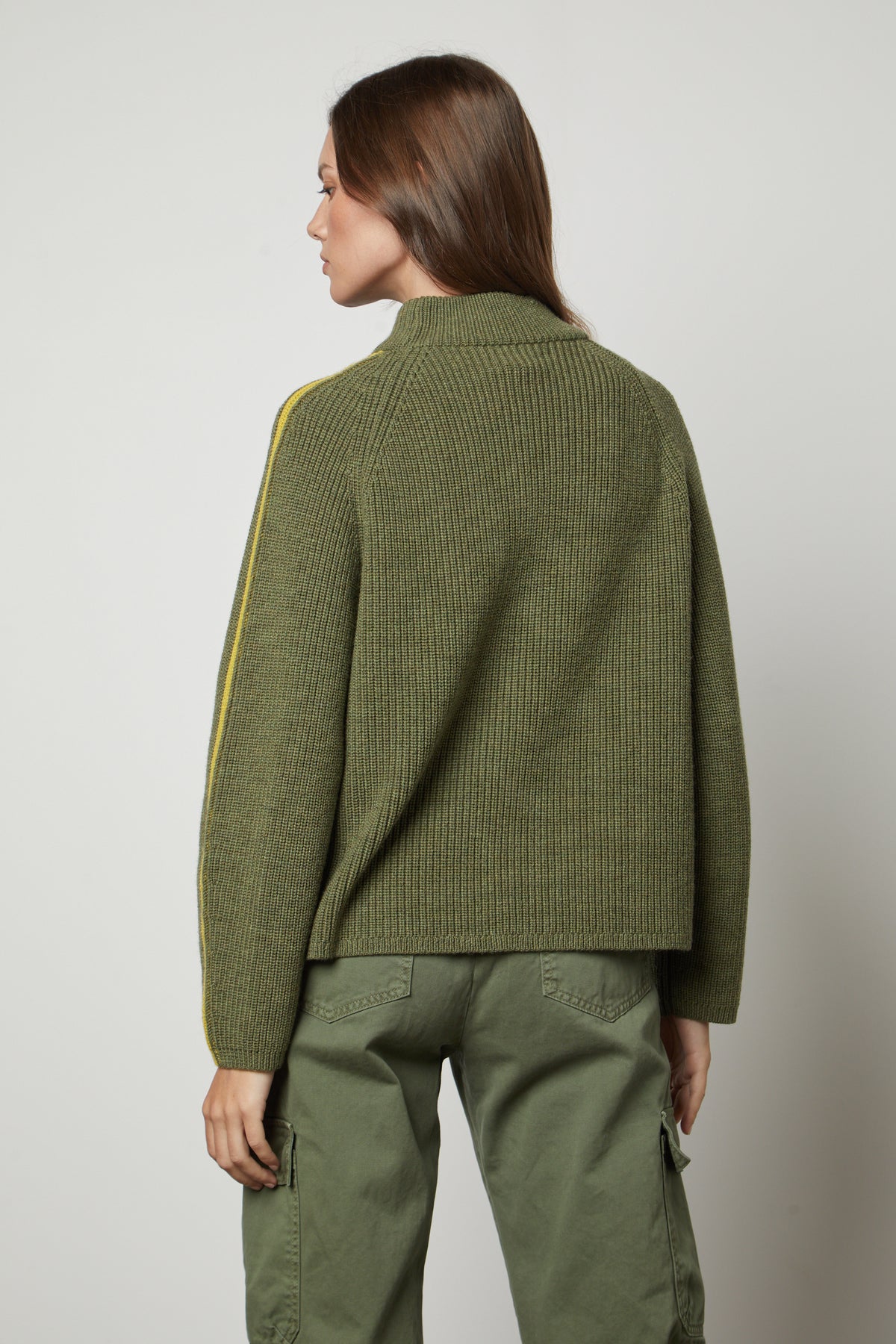 The back view of a woman wearing a Velvet by Graham & Spencer TEAGAN MOCK NECK SWEATER and cargo pants.-26897832247489