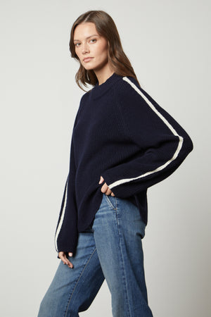 The model is wearing jeans and a Velvet by Graham & Spencer TEAGAN MOCK NECK SWEATER.