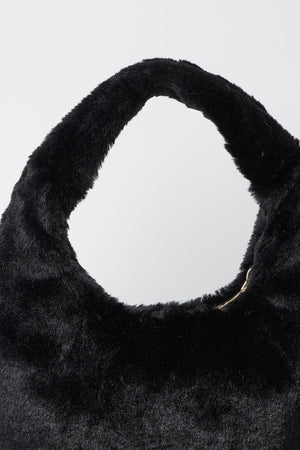 A luxurious FAUX FUR BAG by Velvet by Graham & Spencer on a stylish white surface.