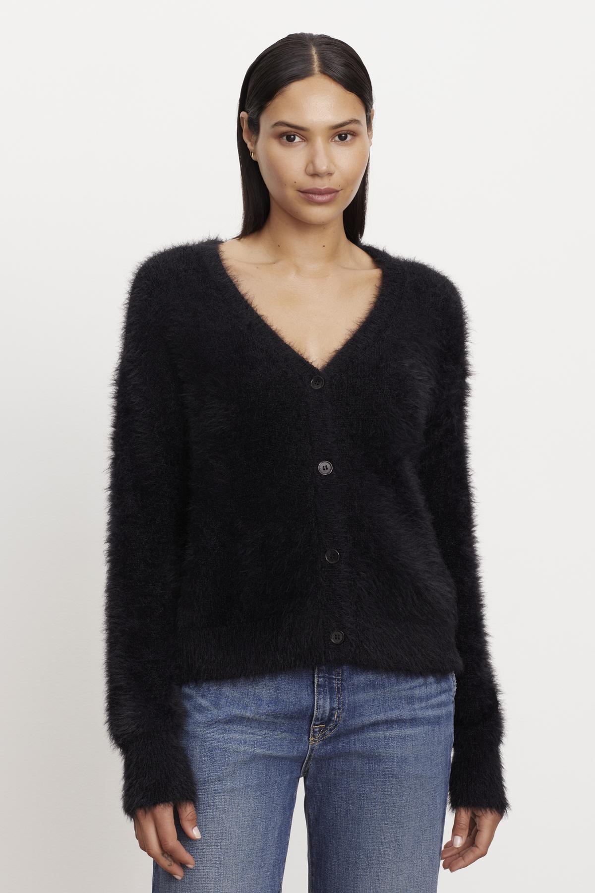 The model is wearing a KELSEY FEATHER YARN CARDIGAN with ribbed trims from Velvet by Graham & Spencer.