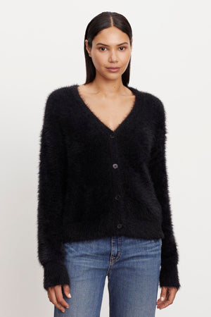 The model is wearing a KELSEY FEATHER YARN CARDIGAN with ribbed trims from Velvet by Graham & Spencer.