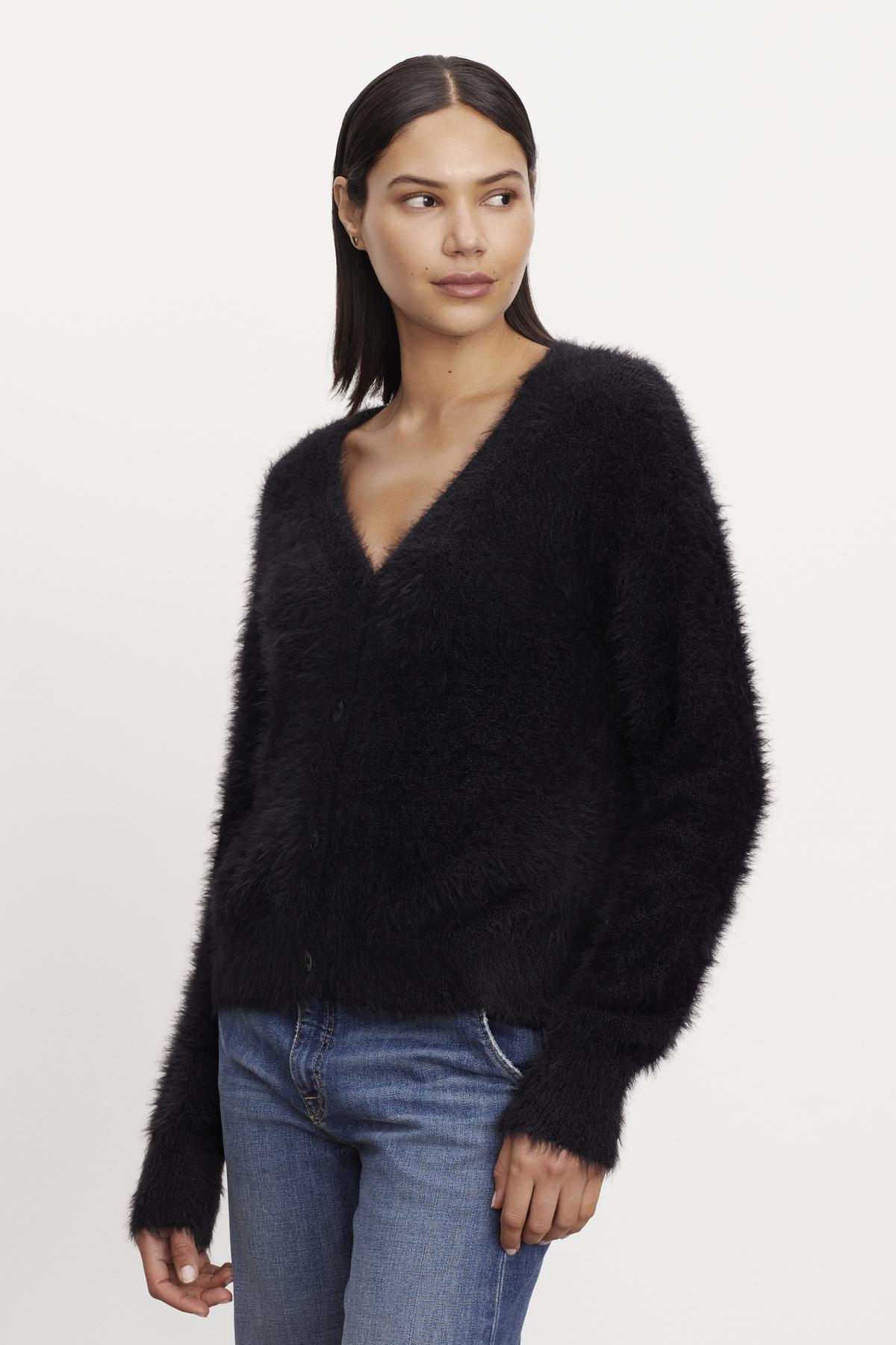 The model is wearing a KELSEY FEATHER YARN CARDIGAN by Velvet by Graham & Spencer with ribbed trims.