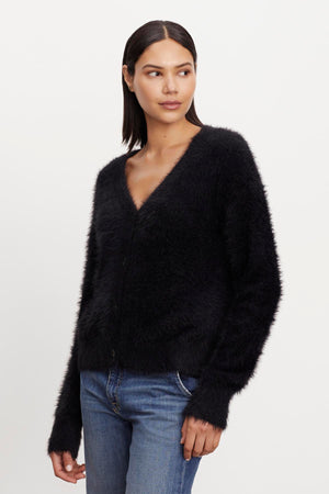 The model is wearing a KELSEY FEATHER YARN CARDIGAN by Velvet by Graham & Spencer with ribbed trims.