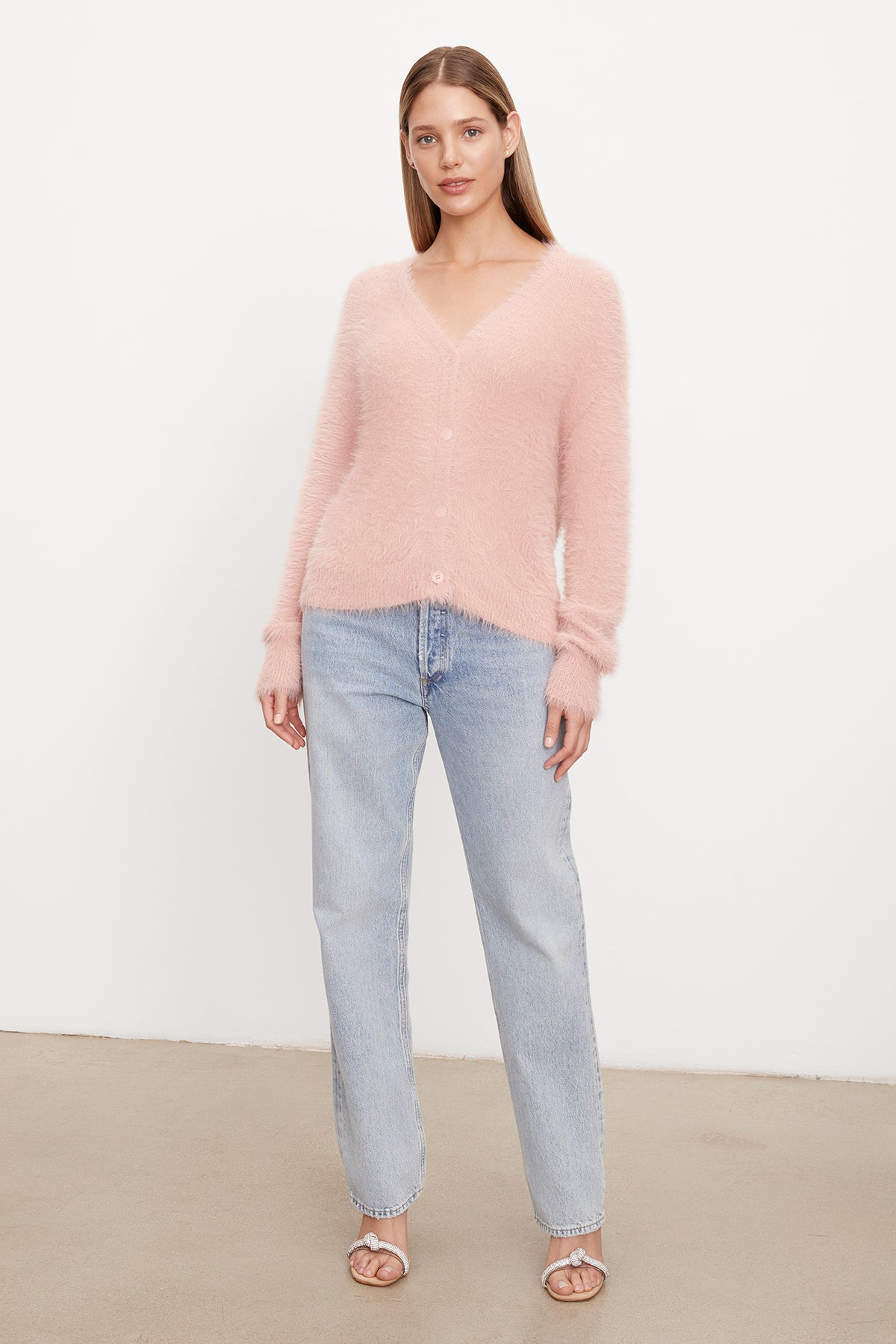 The model is wearing a Velvet by Graham & Spencer KELSEY FEATHER YARN CARDIGAN and jeans.