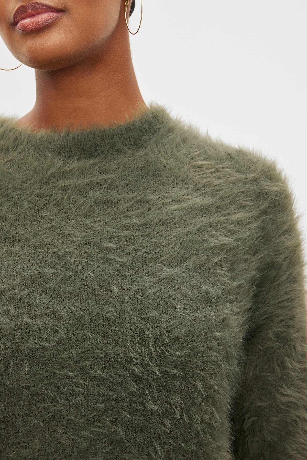 A woman wearing a Velvet by Graham & Spencer RAY FEATHER YARN CREW NECK SWEATER.-35572002717889