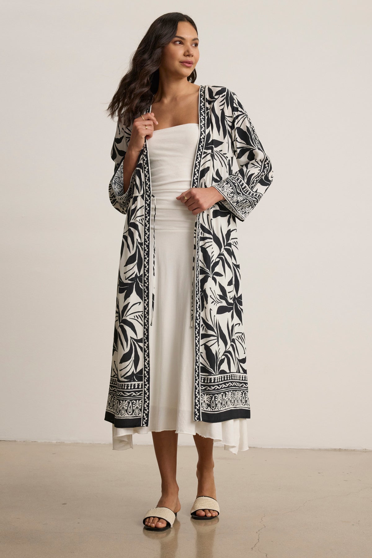 A woman wears the ADDISON COVER UP DRESS by Velvet by Graham & Spencer with flat sandals, posing against a plain background.