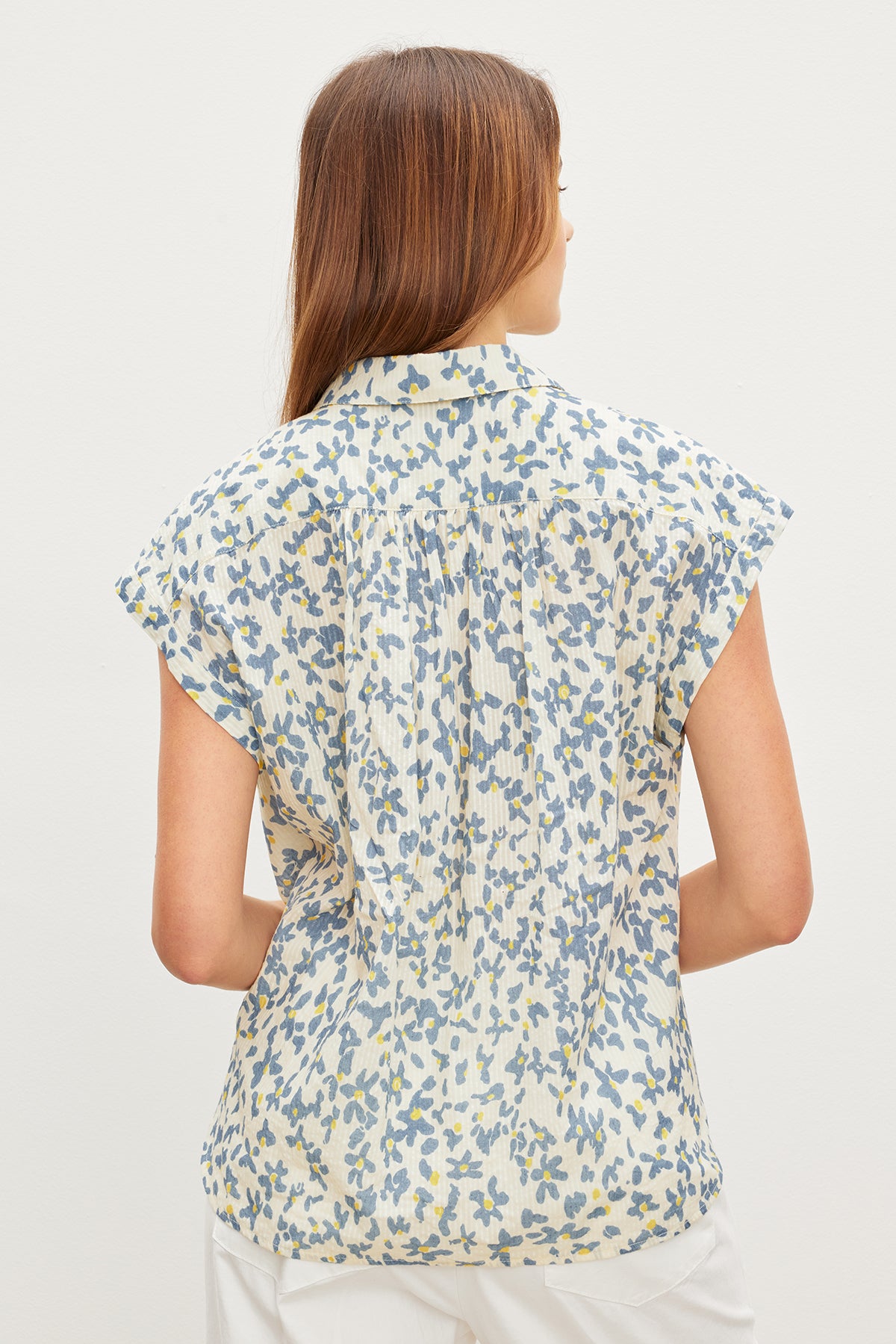 A woman wearing the Velvet by Graham & Spencer Paulette floral button front top with subtle stripe details and a textured cotton feel.