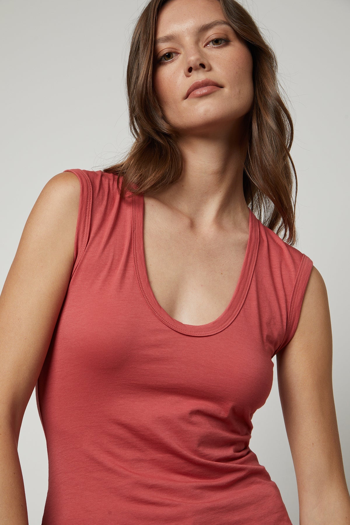 A woman is posing in a Velvet by Graham & Spencer ESTINA GAUZY WHISPER FITTED TANK TOP.