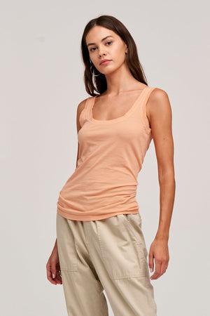 The model is wearing a MOSSY GAUZY WHISPER FITTED TANK by Velvet by Graham & Spencer and tan pants.