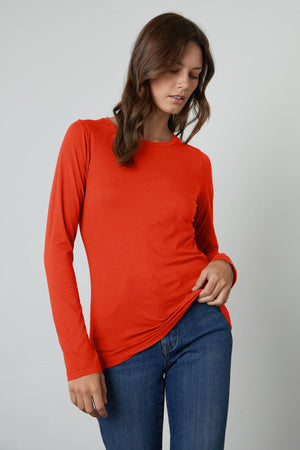 a woman wearing a Velvet by Graham & Spencer ZOFINA GAUZY WHISPER FITTED CREW NECK TEE and jeans.
