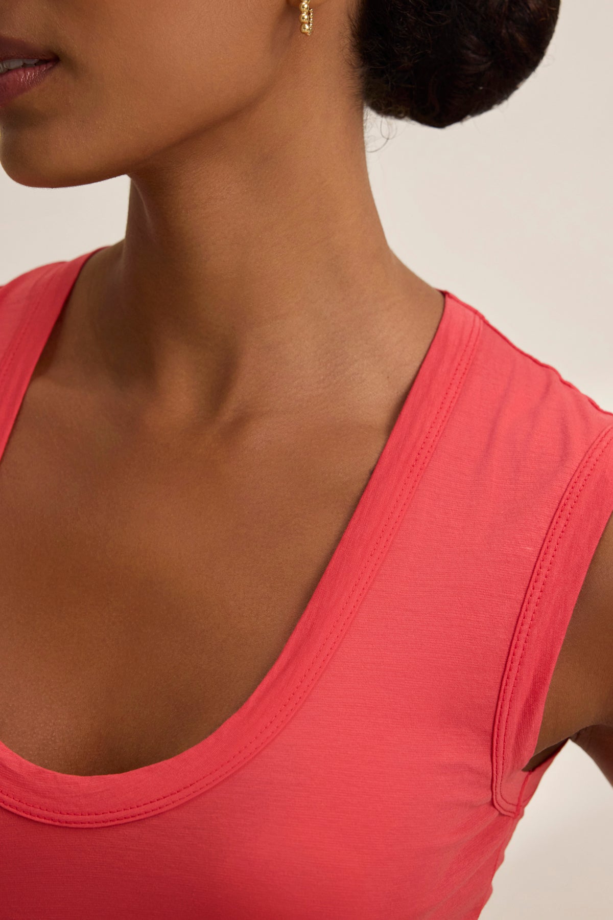 Close-up of a person wearing the Velvet by Graham & Spencer ESTINA TANK TOP and a small gold earring, with hair styled up.-38928283369665