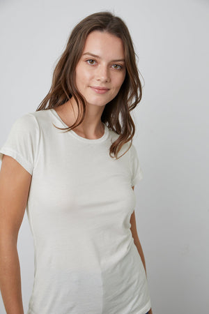 A woman is posing in a Velvet by Graham & Spencer JEMMA GAUZY WHISPER FITTED CREW NECK TEE.