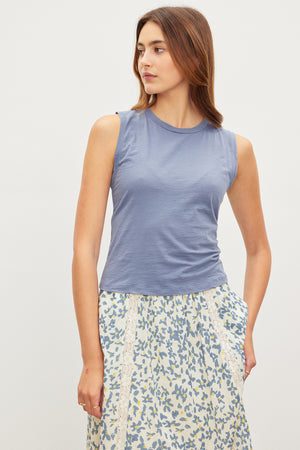A stylish woman wearing a trendy MAGSON CREW NECK TANK TOP by Velvet by Graham & Spencer, crafted from a soft cotton blend and styled as a versatile piece.