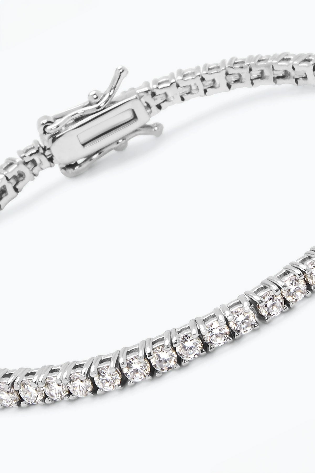 The GLIMMER BRACELET BY PHYLLIS AND ROSIE from Phyllis+Rosie is a stunning silver bracelet with interlocking links, adorned with a row of clear, sparkling gemstones and featuring a secure clasp mechanism. Inspired by New York City's vibrant vintage street culture, this piece embodies the essence of hand-crafted jewelry at its finest.-37832856895681