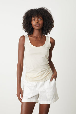 a woman wearing a Velvet by Graham & Spencer MOSSY GAUZY WHISPER FITTED TANK and white shorts.