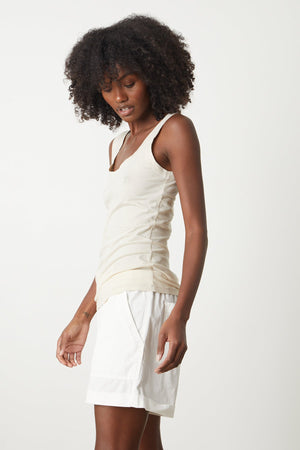a woman in a Velvet by Graham & Spencer MOSSY GAUZY WHISPER FITTED TANK tank top and white shorts.
