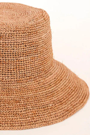 The CHIC CROCHET BUCKET HAT by Velvet by Graham & Spencer features a raffia design with a slightly flared brim, set elegantly against a plain, light background for stylish sun protection.